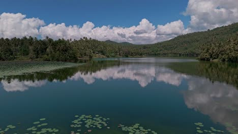 mahucdam lake - surigao del norte, philippines, on a calm bright day with blue sky and jungle all around the waters edge