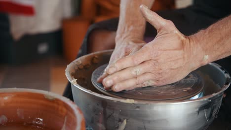 ceramist preparing material to potter's wheel to create a handmade clay product