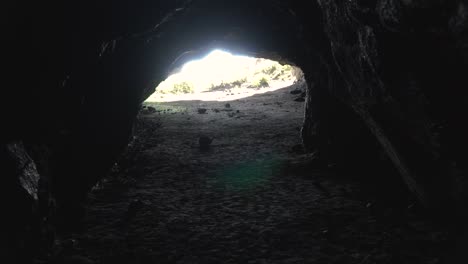 slowmo - daylight sun rays at end of lava cave in new zealand