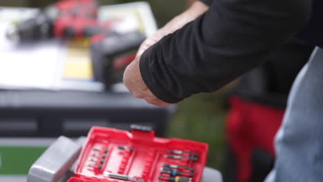 Construction-worker-picking-a-drill-bit-from-a-toolbox