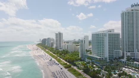 Hilera-De-Modernos-Edificios-De-Varios-Pisos.-Vista-Aérea-De-Hoteles-A-Lo-Largo-De-La-Playa-De-Arena-En-La-Costa-Del-Mar.-Miami,-Estados-Unidos