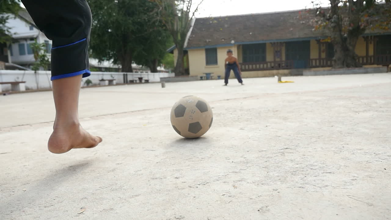 Children Playing Soccer in a Cambodian Courtyard