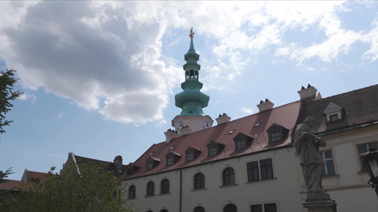 Michaelsporten i Bratislava på en solrig dag med udsigt til historiske bygninger og grønne træer.