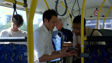 Paar-Diskutiert-über-Ein-Digitales-Tablet,-Während-Es-Im-Bus-4k-Unterwegs-Ist