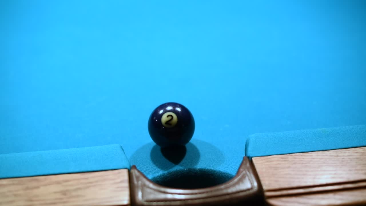 Close up shot of making Two ball in the side pocket in american pool billiard