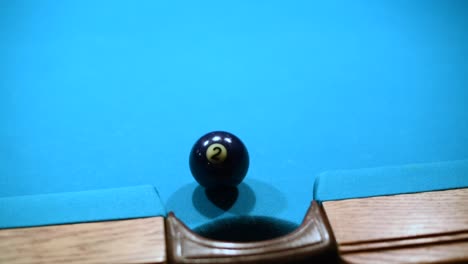 close up shot of making two ball in the side pocket in american pool billiard