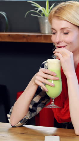 woman drinking green milkshake