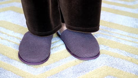 person wearing slippers on a patterned carpet