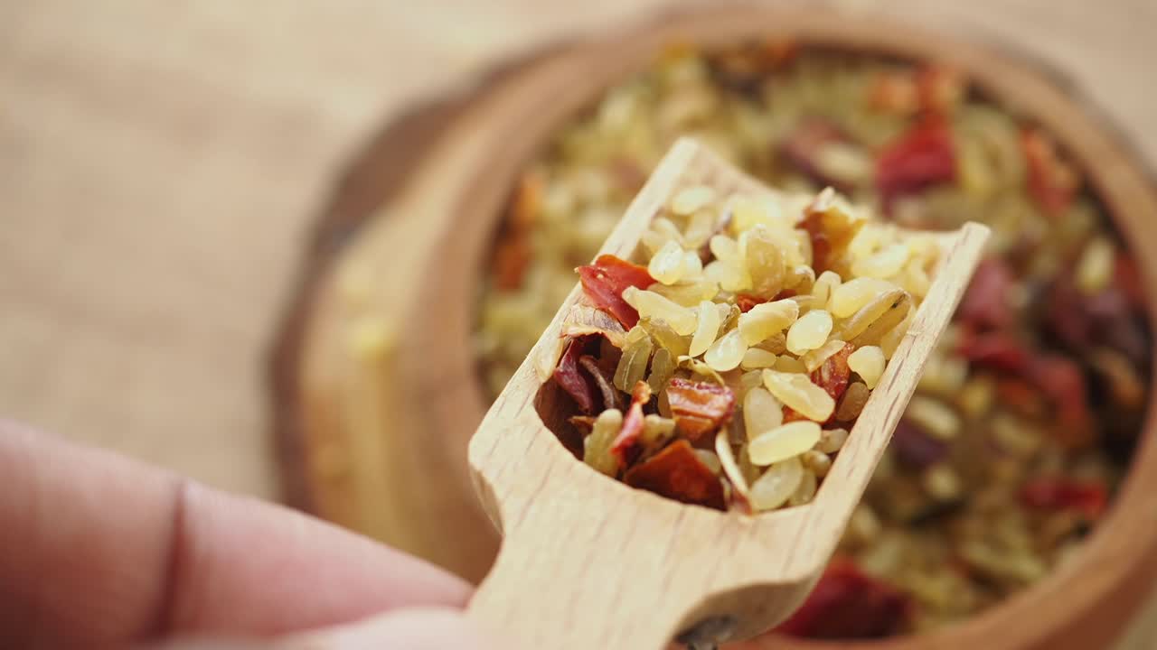 Scooping Mixed Spices from a Wooden Bowl