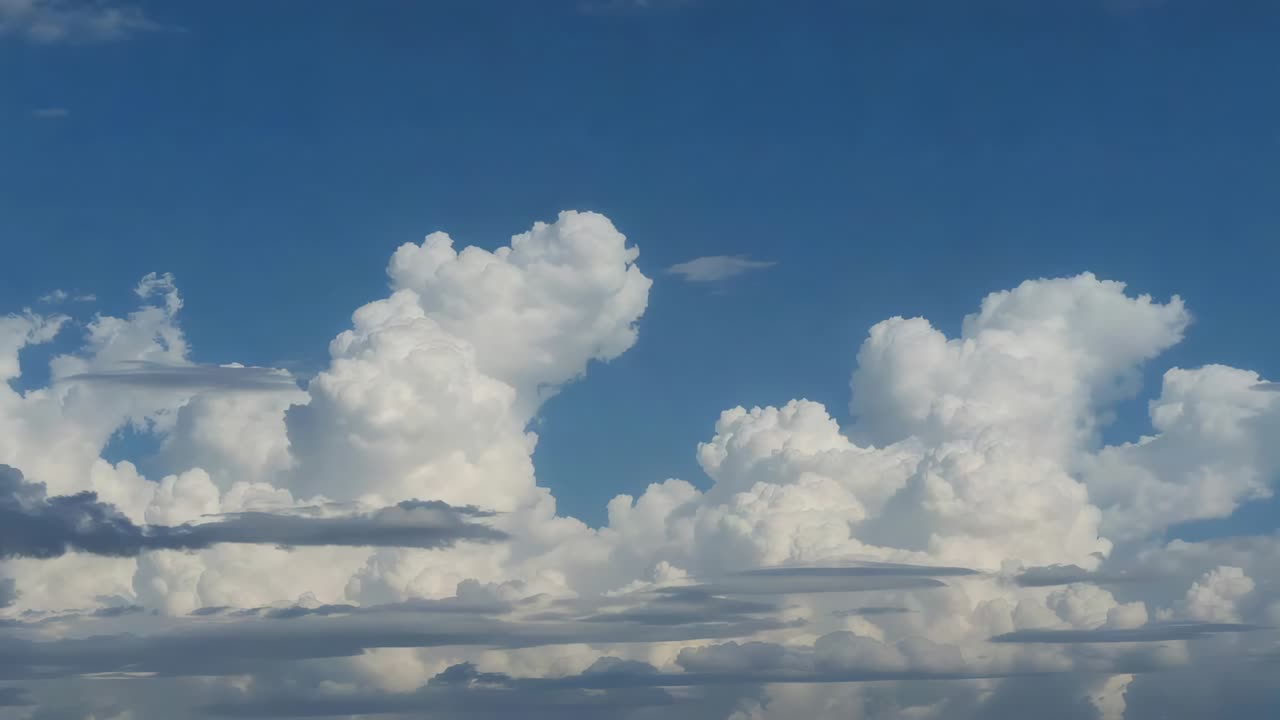 Shifting cumulus cluster drifting right in clear sky by gentle wind, with thin stratocumulus layers