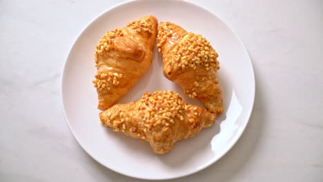 新鮮的 croissant 和花生在盤子上