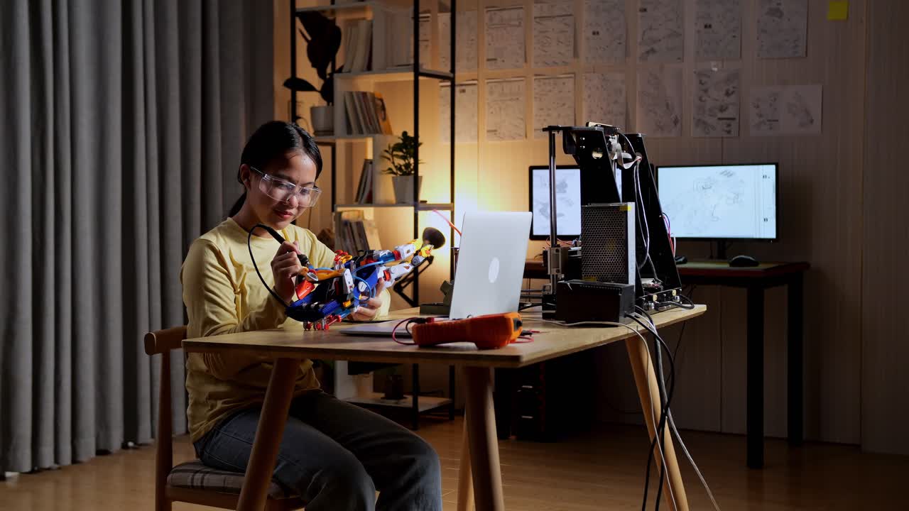 십대 아시아 소녀가 집에서 사이보그 손을 수리하고 있습니다.