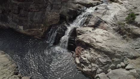 woolshed falls with water cascading down rocks in beechworth, australia - aerial drone shot