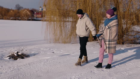 couple walking hand-in-hand on a snowy path