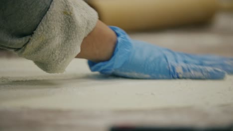 baker cutting circle out of freshly rolled dough for pie crust