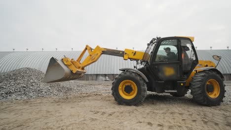 tractor moves rubble to truck. excavator-loader rakes rubble from pile at construction site and loads dump truck. clearing site