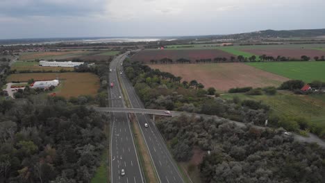 aerial drone orbit showing of busy hungarian highway, beautiful lake in the background