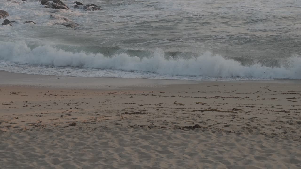 Onde del mare che si infrangono sulla sabbia con movimento naturale.