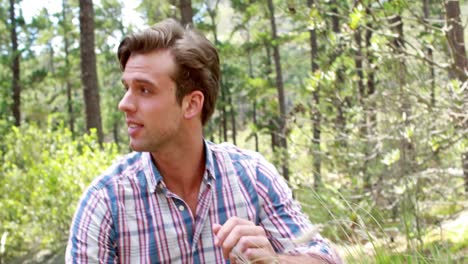 Smiling-hiker-man-looking-at-plant