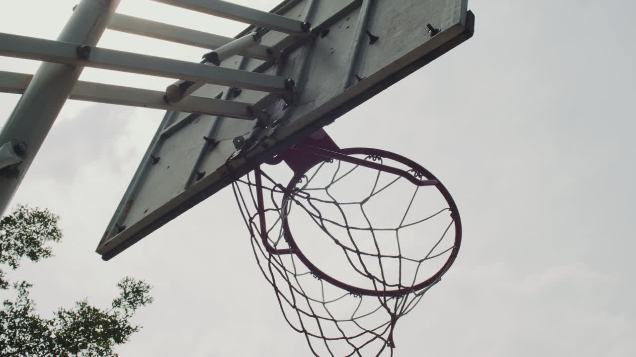 Ball Being Thrown in Basketball Ring with Net outdoors