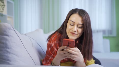 Mujer-Joven-Feliz-Y-Linda-Enviando-Mensajes-De-Texto-En-Casa.