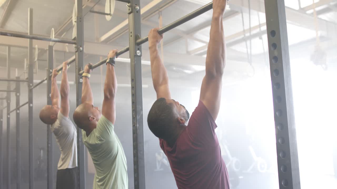 diversas clases de acondicionamiento físico de grupo masculino en el gimnasio haciendo flexiones en barras, en cámara lenta