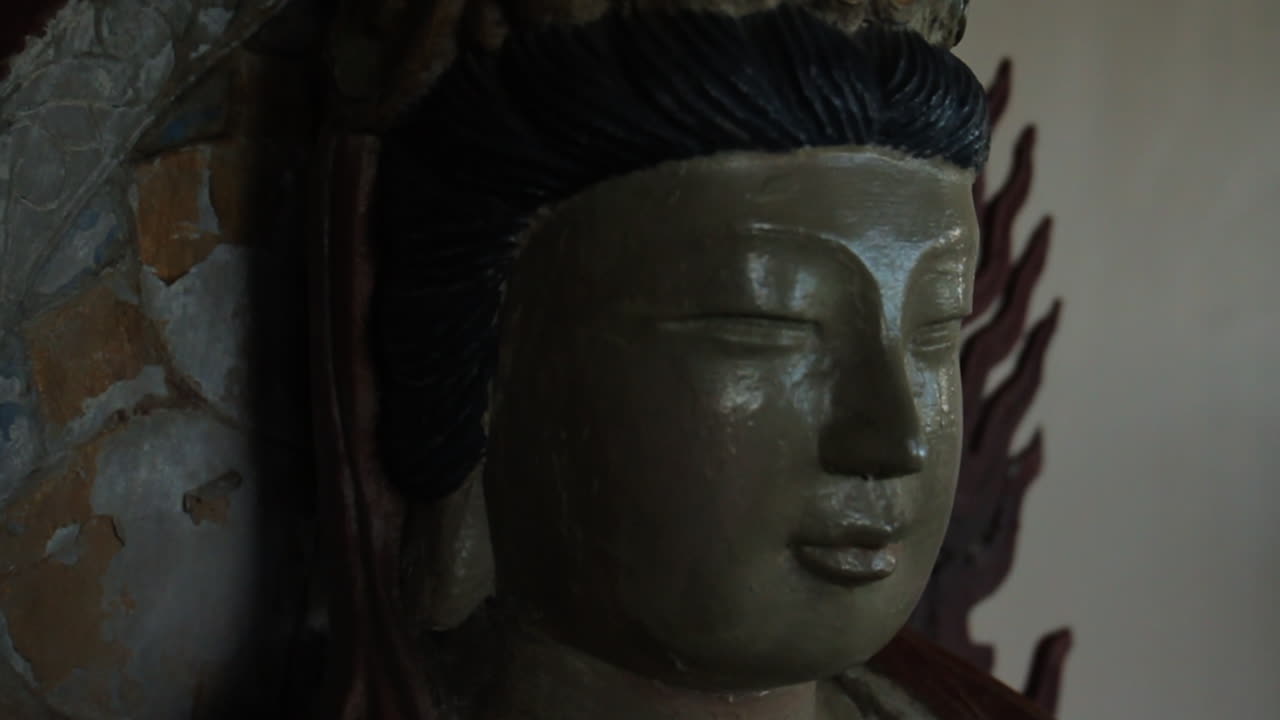 la estatua de buda se sienta contra el muro de hormigón