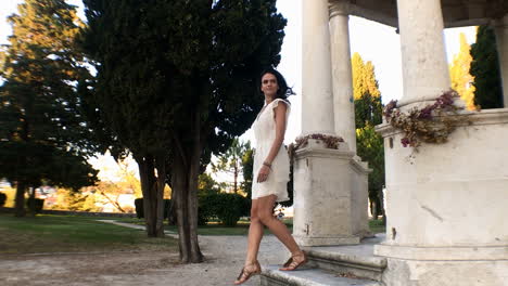 slow motion shot of beautiful girl in white dress walking stairs in park , split, dalmatia, croatia