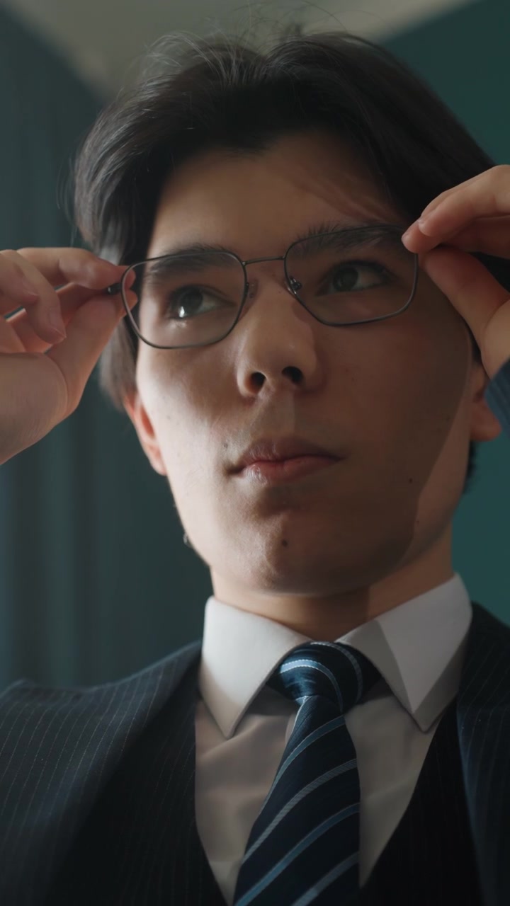 亞洲專業人士試戴眼鏡，評估視力與儀態；中級分析師檢查鏡片，摘下眼鏡以看清事物，用手指撥弄頭髮，在自然光窗邊堅定地向上望。