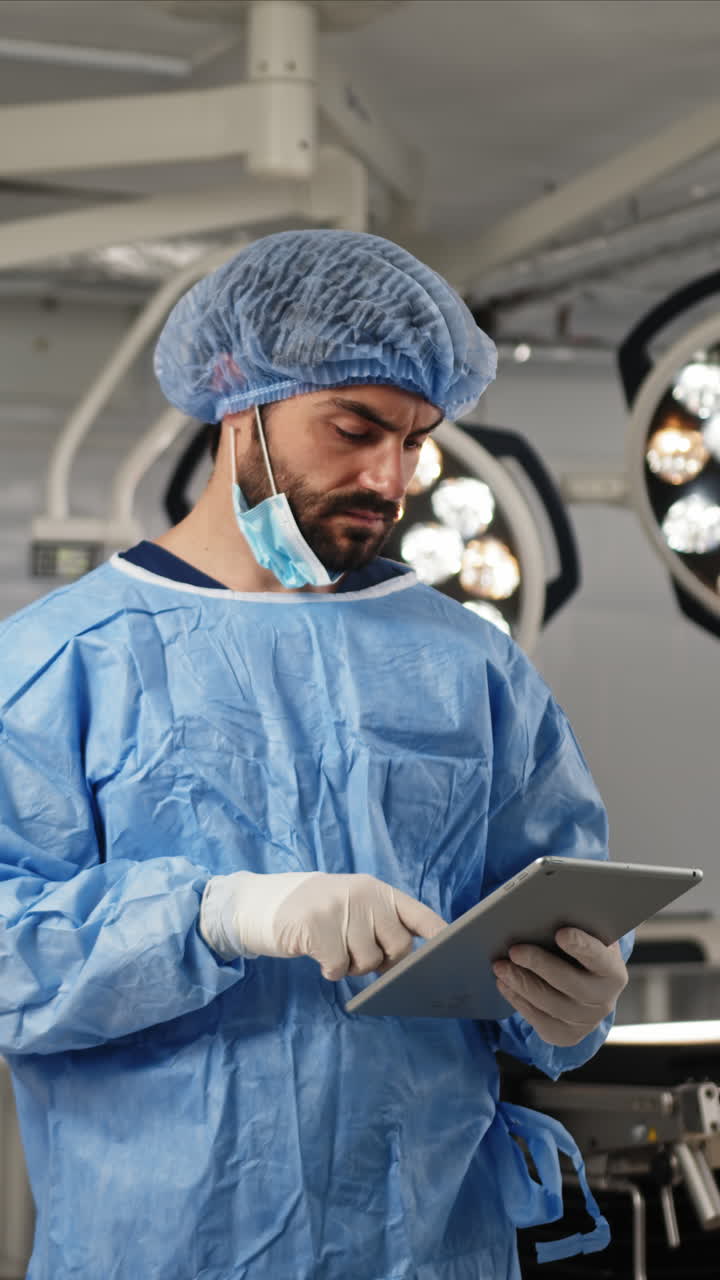 Cirujano examinando una tablet en el quirófano