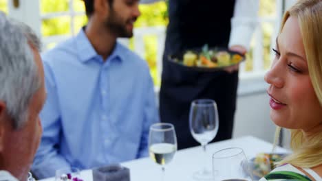 camarero que sirve comida a los clientes