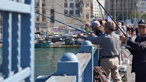 men fishing from a bridge in istanbul, turkey