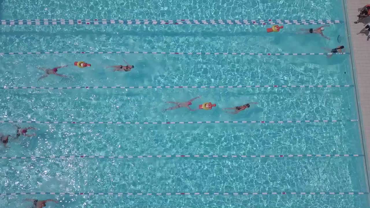 A high view of a public swimming pool with people who swim together