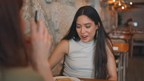 two women enjoying conversation in a cafe