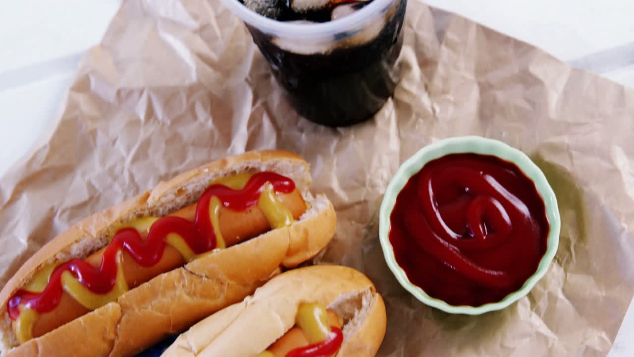 핫도그, 차가운 음료와 갈색 종이에 소스