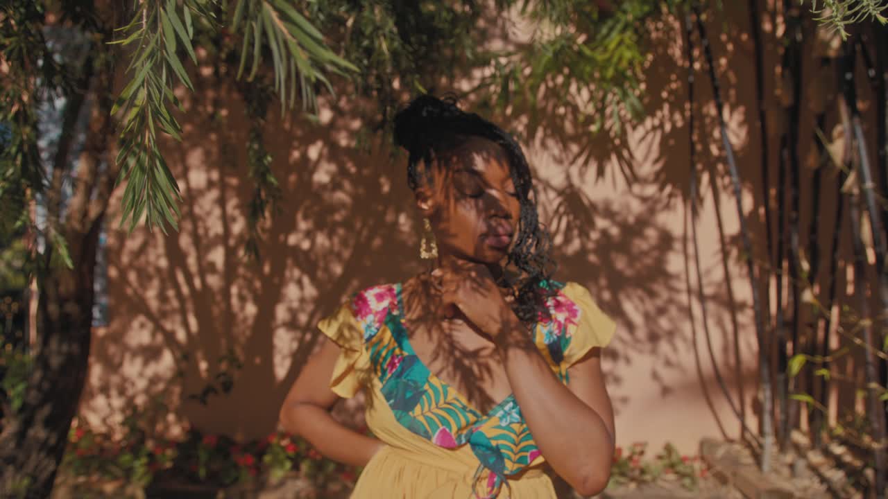 Stylish Woman in a Yellow Floral Dress Outdoors
