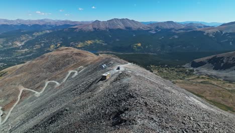 aerial view of a mountain peak with winding road and cars