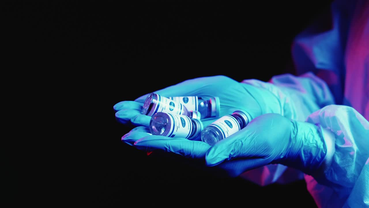 viales de vacuna contra la covid-19 en manos de médicos con guantes
