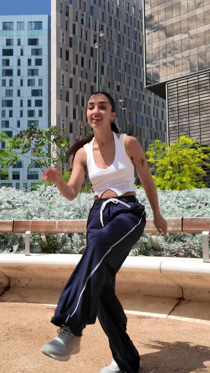 Woman dancing in a park in an urban setting