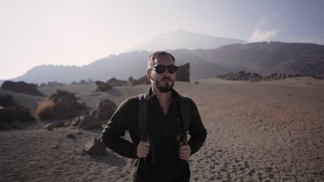 Hot-handsome-hispanic-backpacker-strolling-at-desert-area-of-Tenerife-Teide-Spain