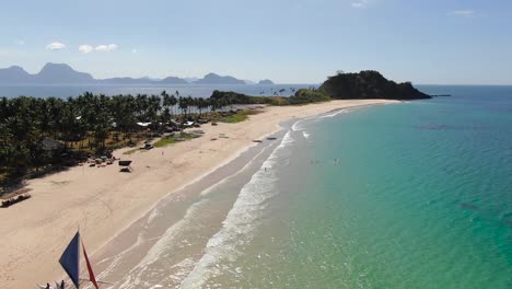 Hermosa-Playa-Con-Gente-Y-Un-Velero