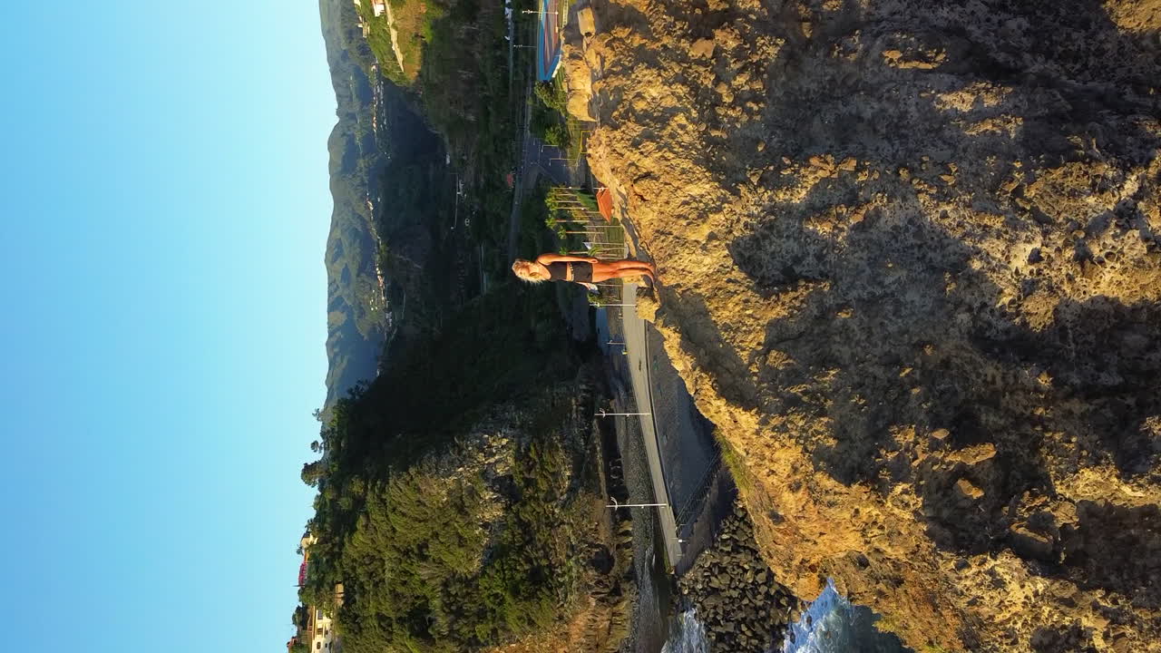 mujer en un acantilado con vistas al océano