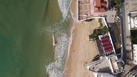 Sandy-beach-and-waves-of-Atlantic-Ocean-on-popular-seaside-resort-Armacao-de-Pera,-Portugal,-birds-eye-view