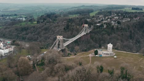 Aerial-shot-of-the-Clifton-suspension-bridge-circling-around-over-the-River-Avon,-Bristol,-during-overcast-cloudy-day