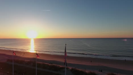 Volando-Sobre-Banderas-Americanas-En-Myrtle-Beach-Al-Amanecer-A-Lo-Largo-De-La-Orilla