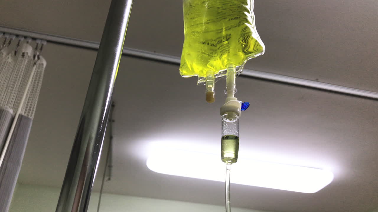 bolsa amarilla de terapia de quelación intravenosa goteando lentamente en una habitación de hospital
