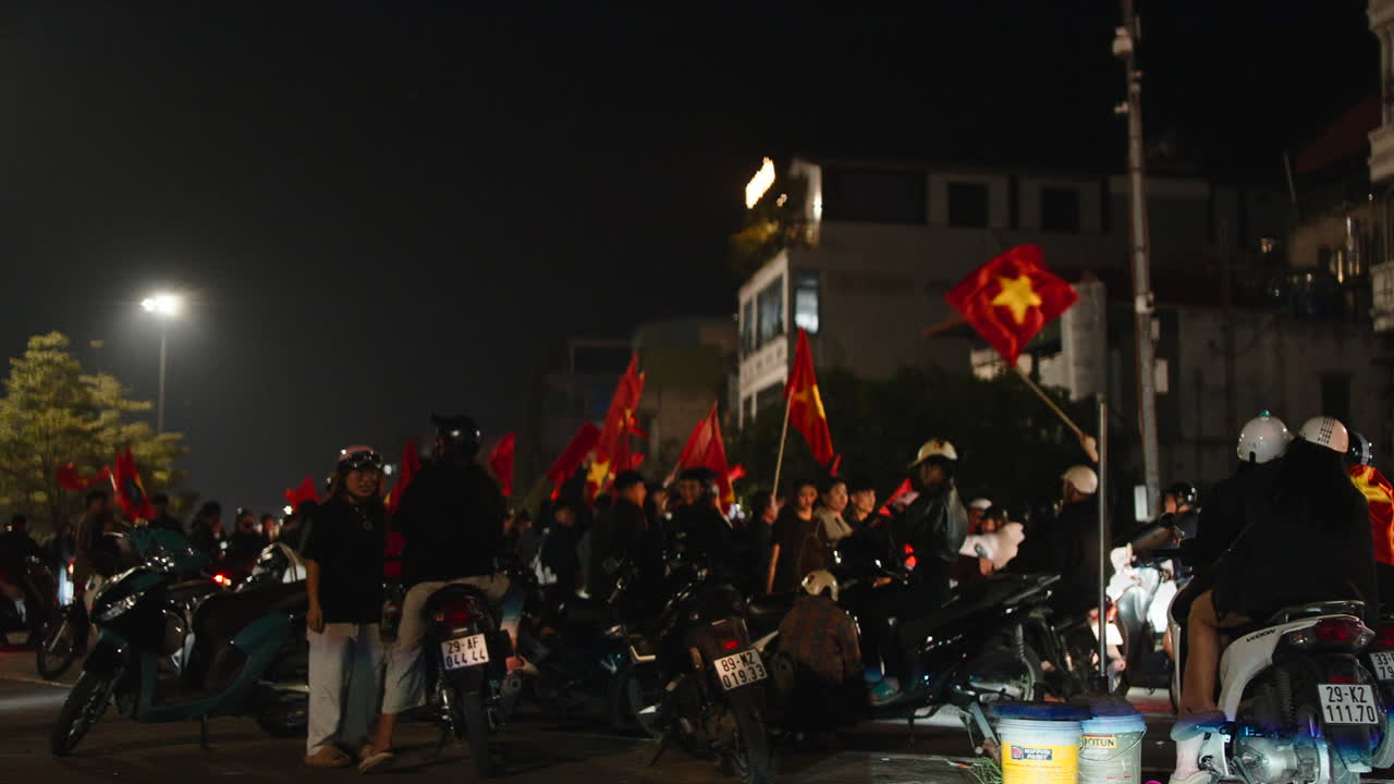 Folla di persone con bandiere vietnamite su motociclette di notte