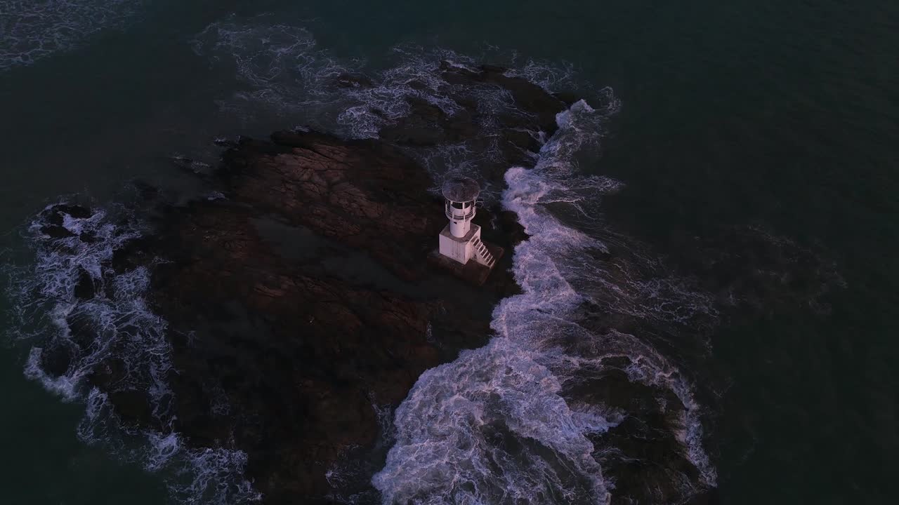 Lighthouse on Rocky Coast with Crashing Waves