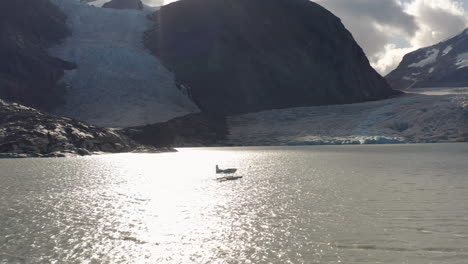 una fotografía de un avión marítimo en un lago glaciar en las montañas de la columbia británica antes de despegar