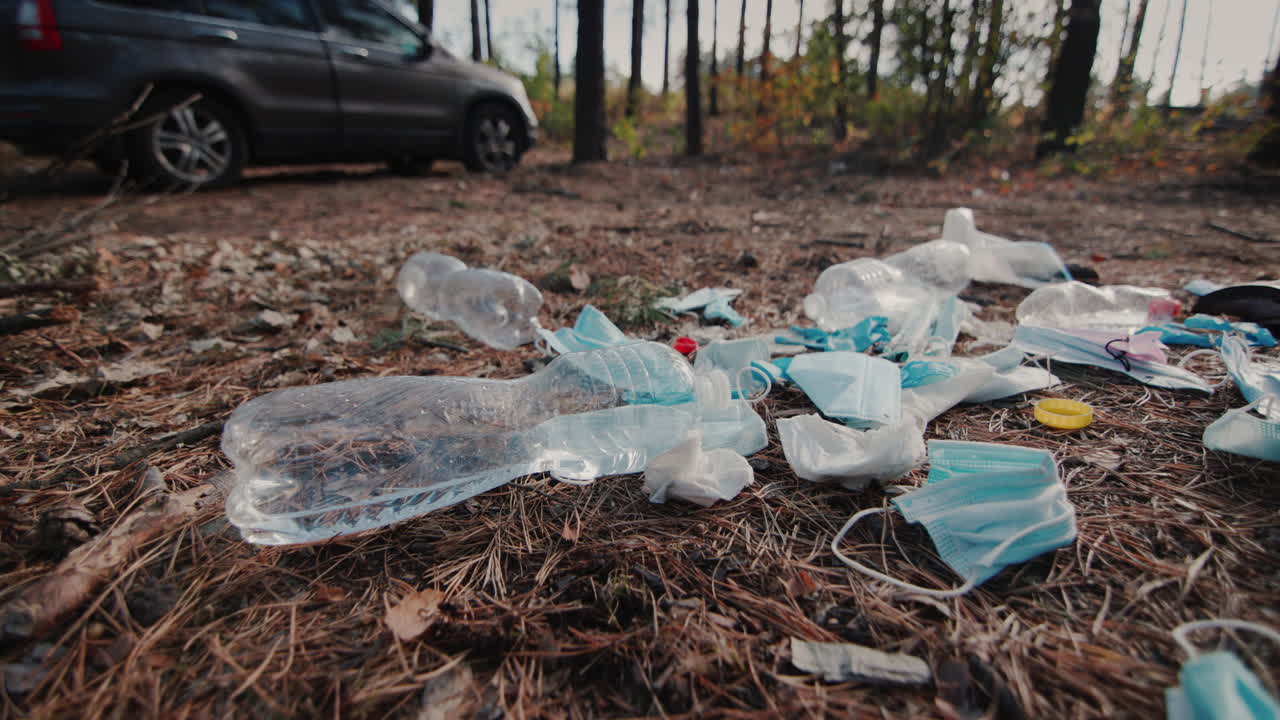 persona tira basura en el bosque